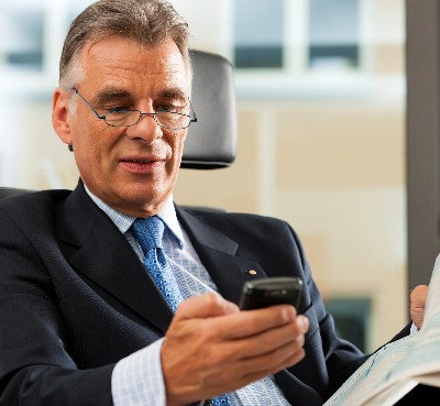 Man on Smartphone with Newspaper
